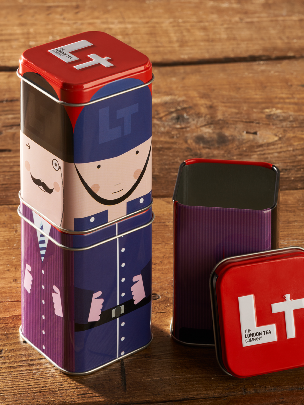 Quirky stackable tin packaging with a red lid.