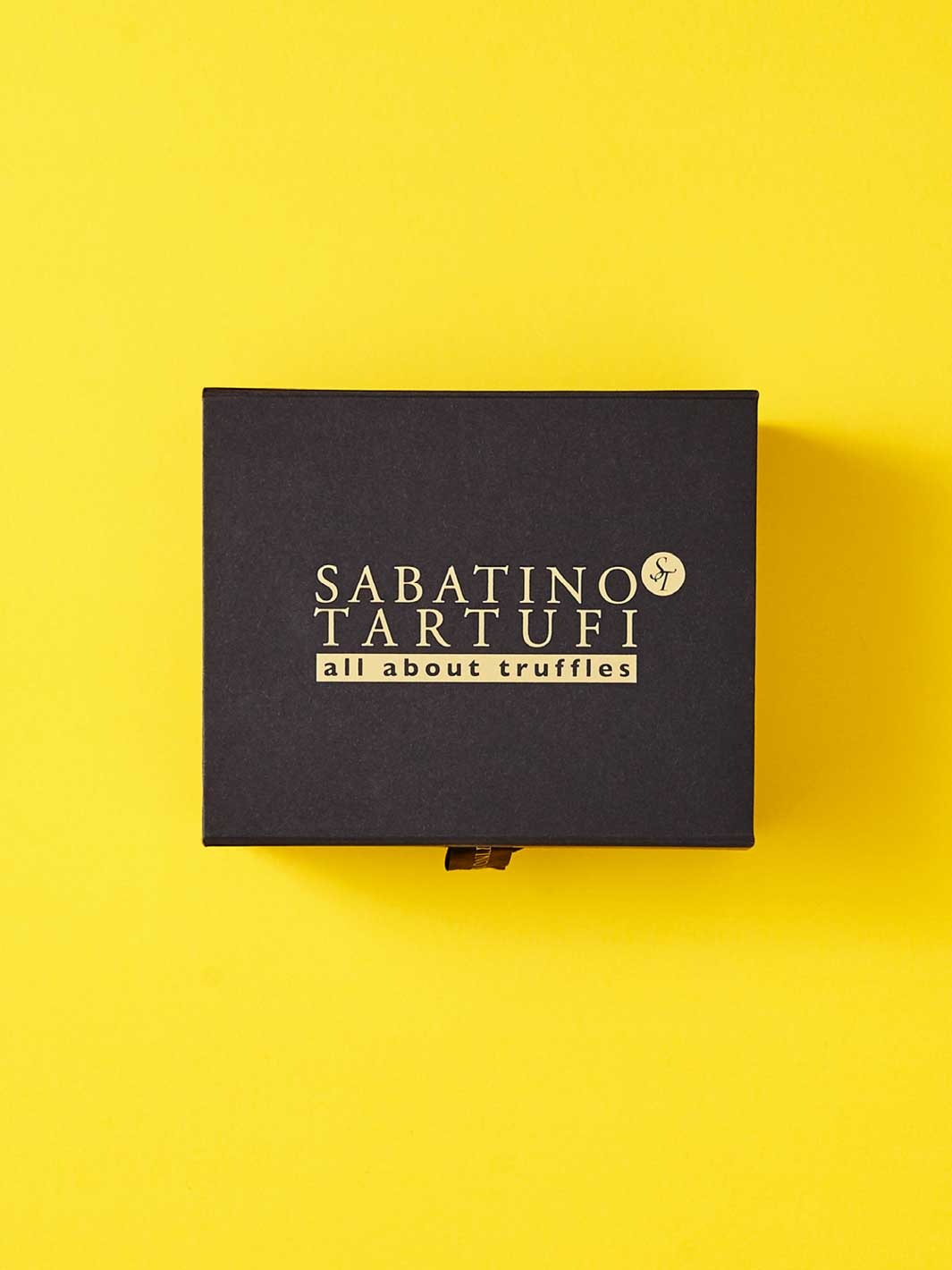 Black custom cardboard packaging on a yellow background. 